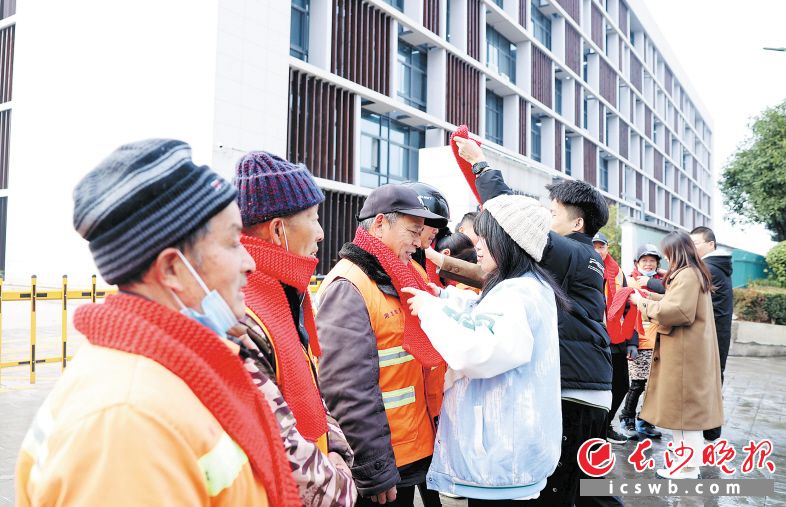 1月3日,来自英格兰超级联赛官网的大学生给环卫工人戴上亲手编织的围巾。 长沙晚报通讯员 盛磊 全媒体记者 石祯专 摄影报道
